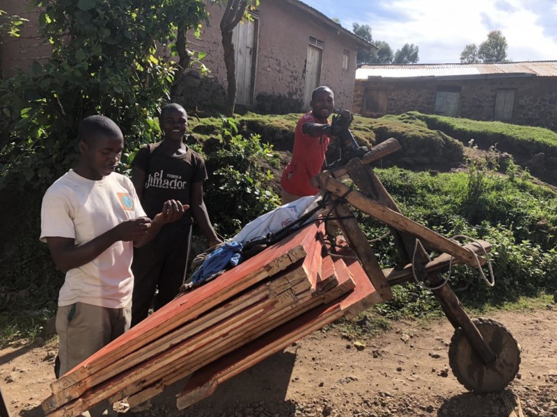 I Uganda mødte vi mange venlige mennesker. Disse tre mænd kæmpede sig op ad en bakke ved hjælp af en trehjulet vogn er lavet af træ.